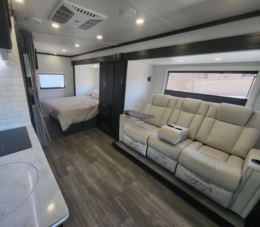 Isata 3 24FW living area with theater seating and corner queen bed